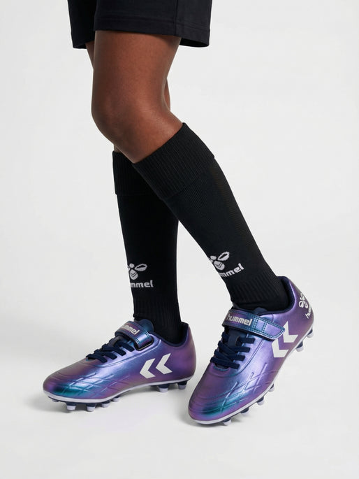 A football boot by Hummel, style Top Star F.G JR in green/multi with elastic laces, velcro strap and Hummel logo on side. Image of child wearing football boots with Hummel branded socks