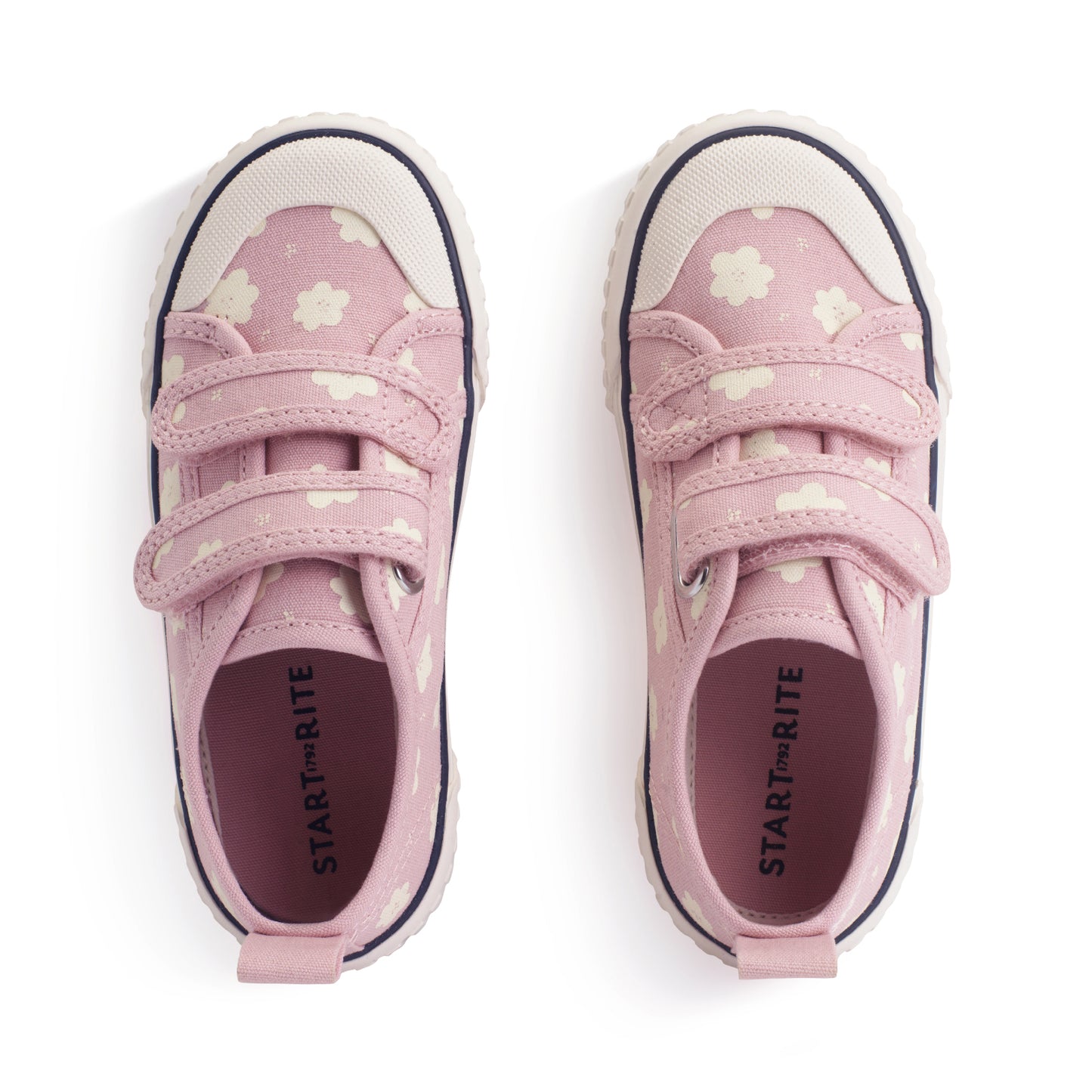 A girls canvas shoe by StartRite, style Tide in dusky pink with white flower pattern, two velcro straps and white toe bumper. Top view of pair