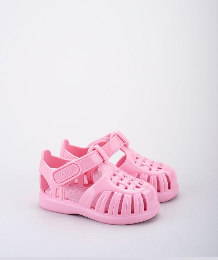 A girls's closed toe unisex jelly sandal by Igor, style Tobby Solid, in vanilla with velcro fastening. Angled view of pair.