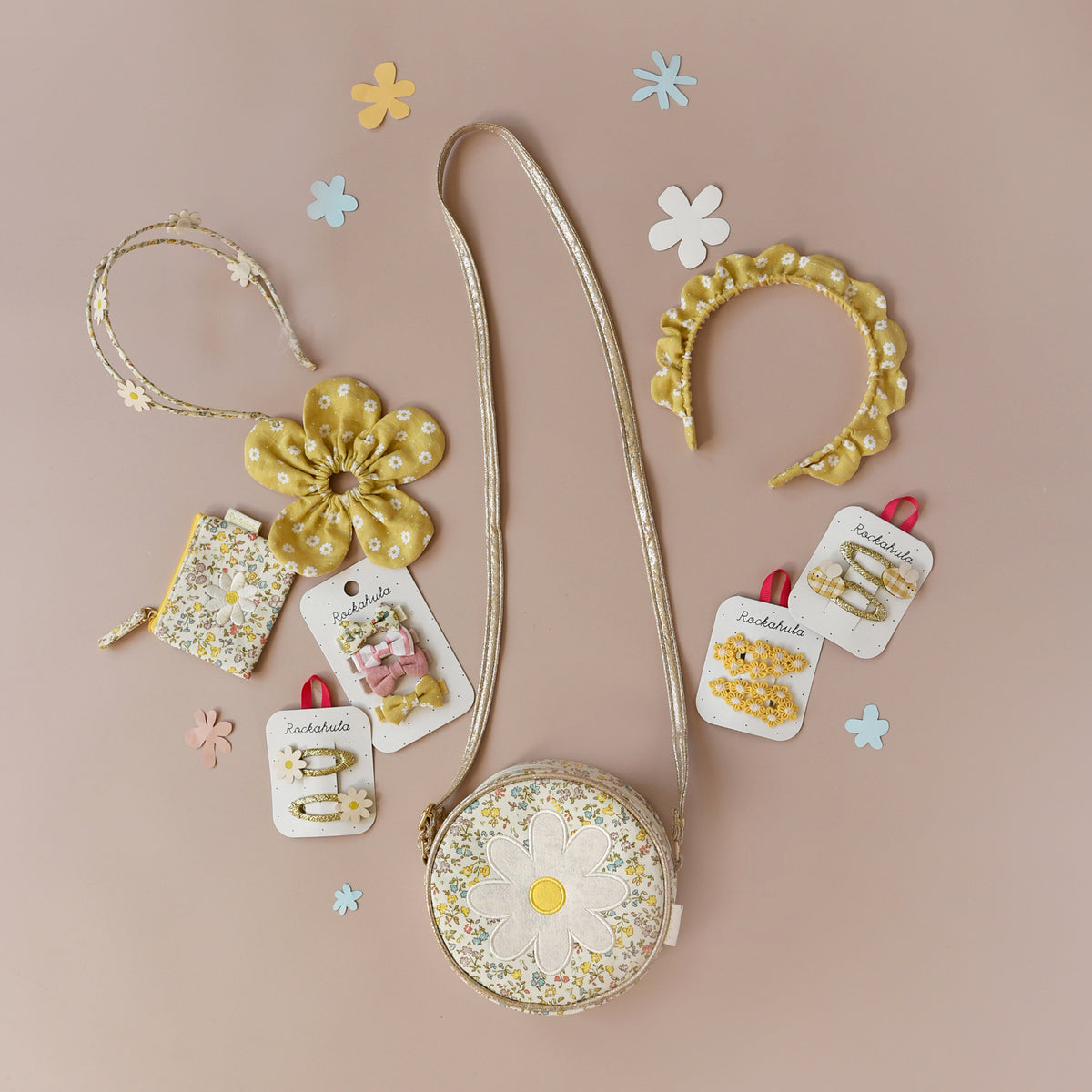 Set of floral accessories by Rockahula including a bag, hair clips, and headband on a beige background.