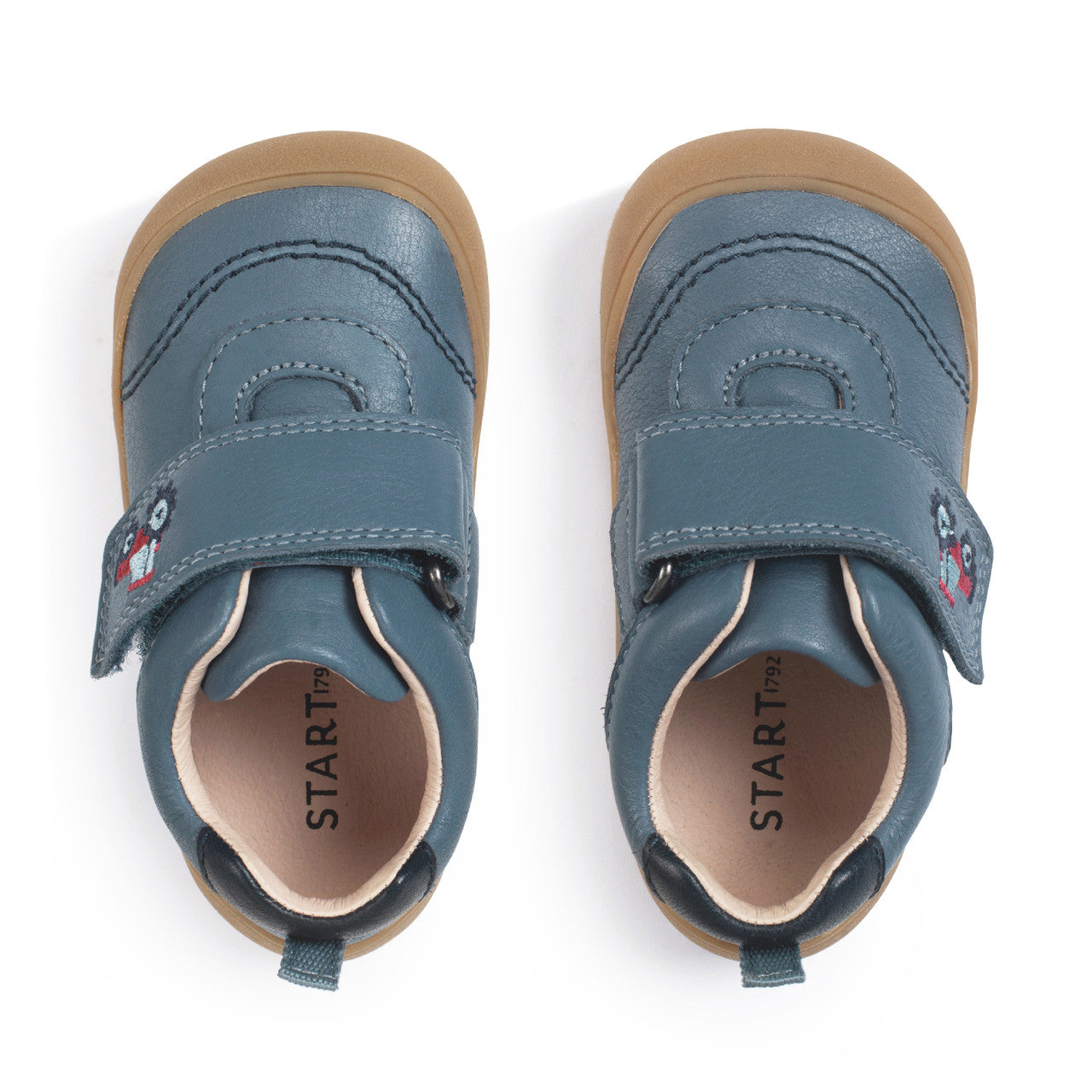 A boys casual shoe by Start-Rite, style Harvest, in blue with heel and toe bumpers and red tractor detail to the velcro fastening. View of pair from above.