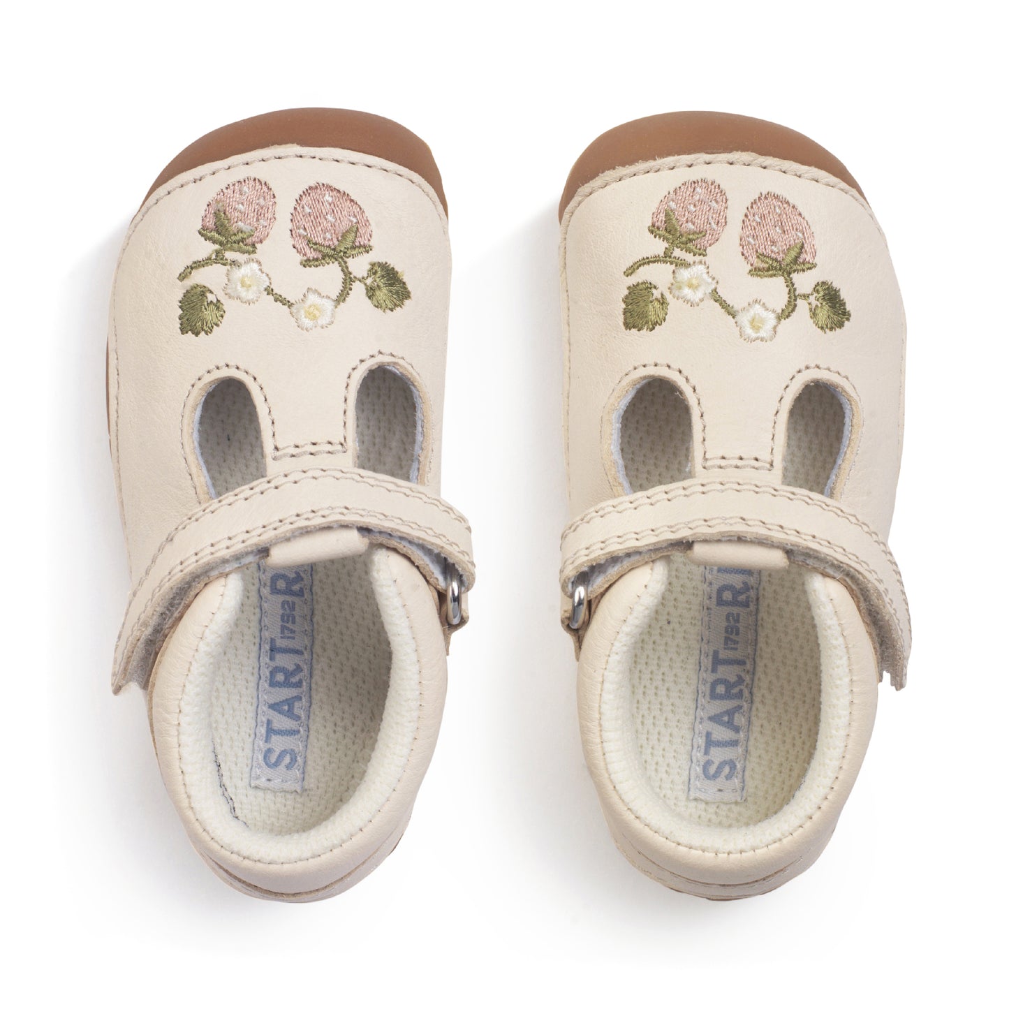 A girls pre-walker shoe by StartRite, style squish in cream with strawberry detail on front and t-bar velcro strap. Top view of pair