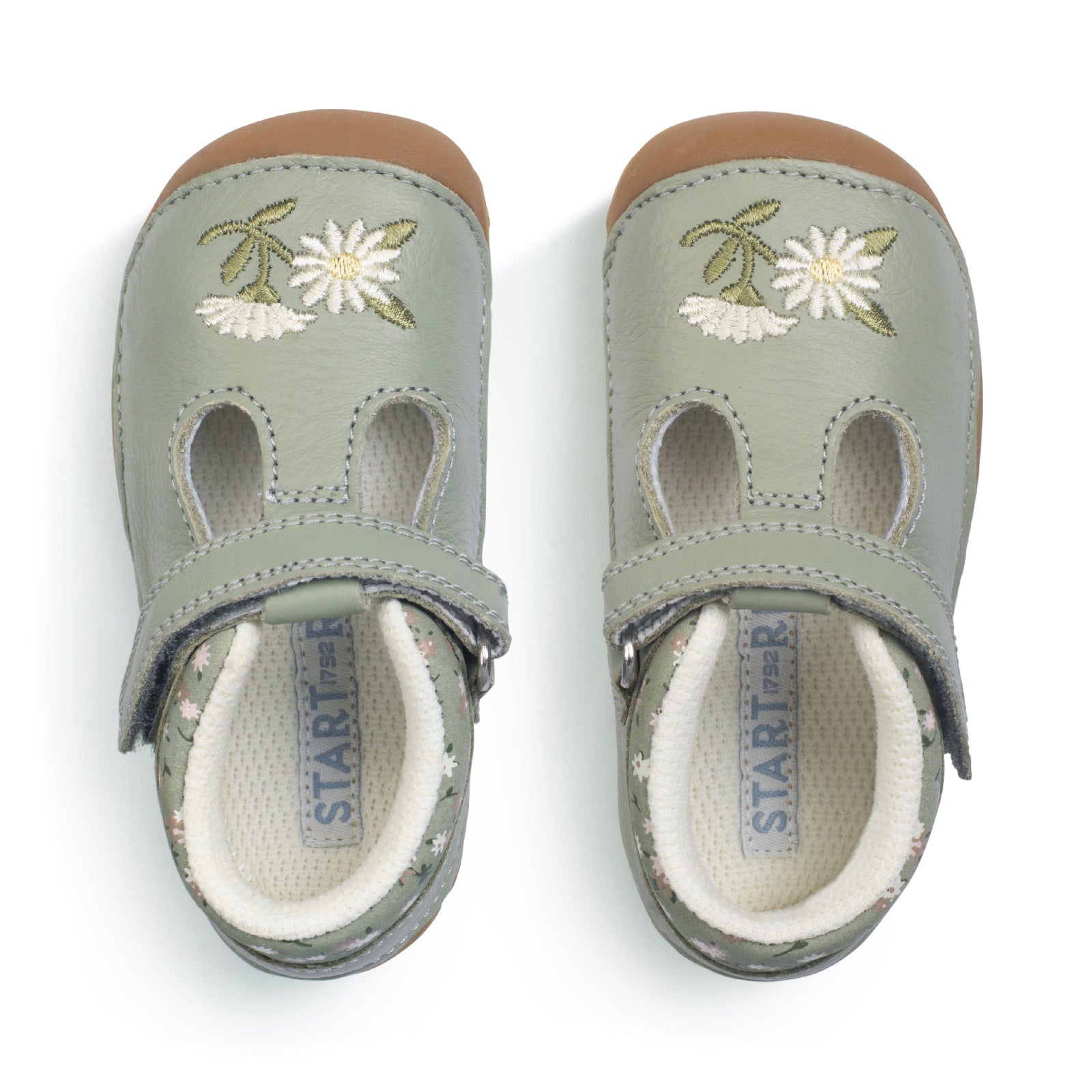 A girls pre-walker shoe by StartRite, style Squish in dusky green with flower detail on front and ankle, with t-bar velcro strap. Top view of pair