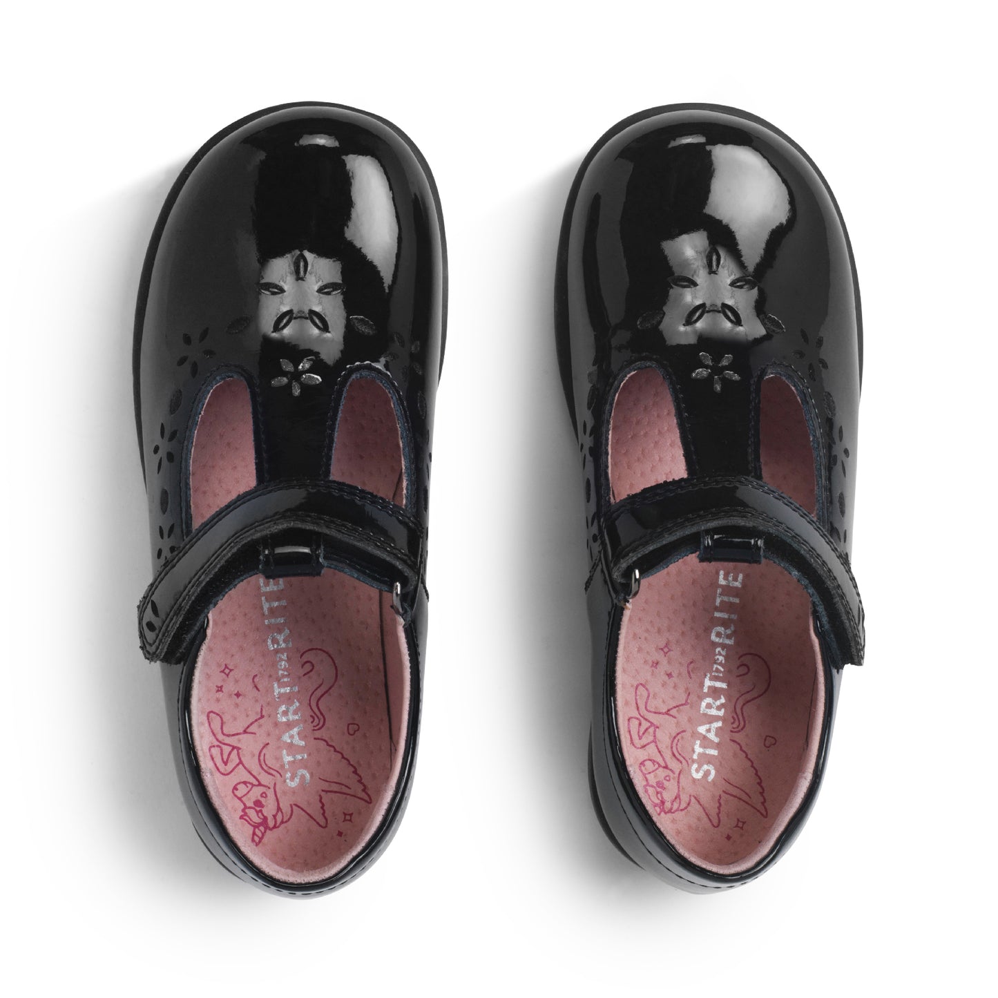 A girls T-Bar school shoe by Start-Rite, style Charlotte, with flower detail in black patent with velcro fastening. View of pair from above.