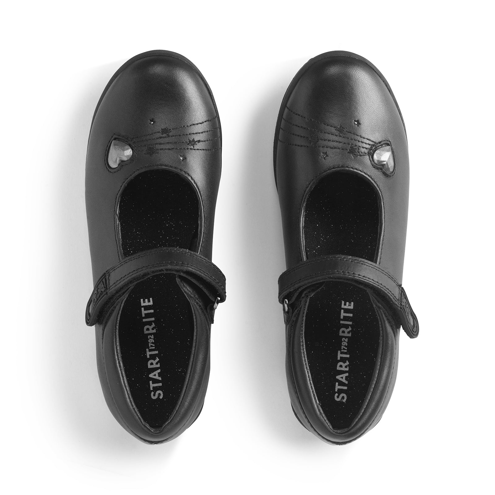 A girls Mary-Jane shoe by Start-Rite, style Startdust, in black leather with heart detail and velcro fastening. View of pair from above.