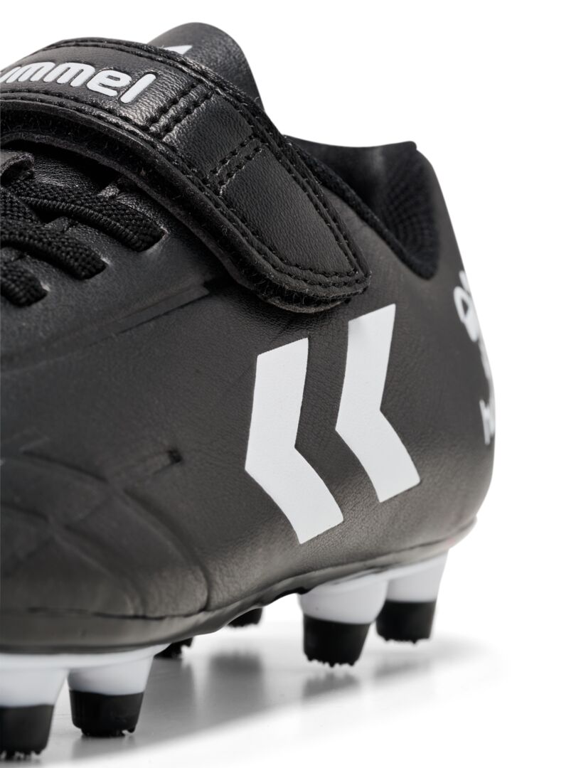 A firm ground football boot by Hummel, style Top Star F.G JR 216568-2042, in black and white with elastic lace and velcro fastening. Close up angled view.