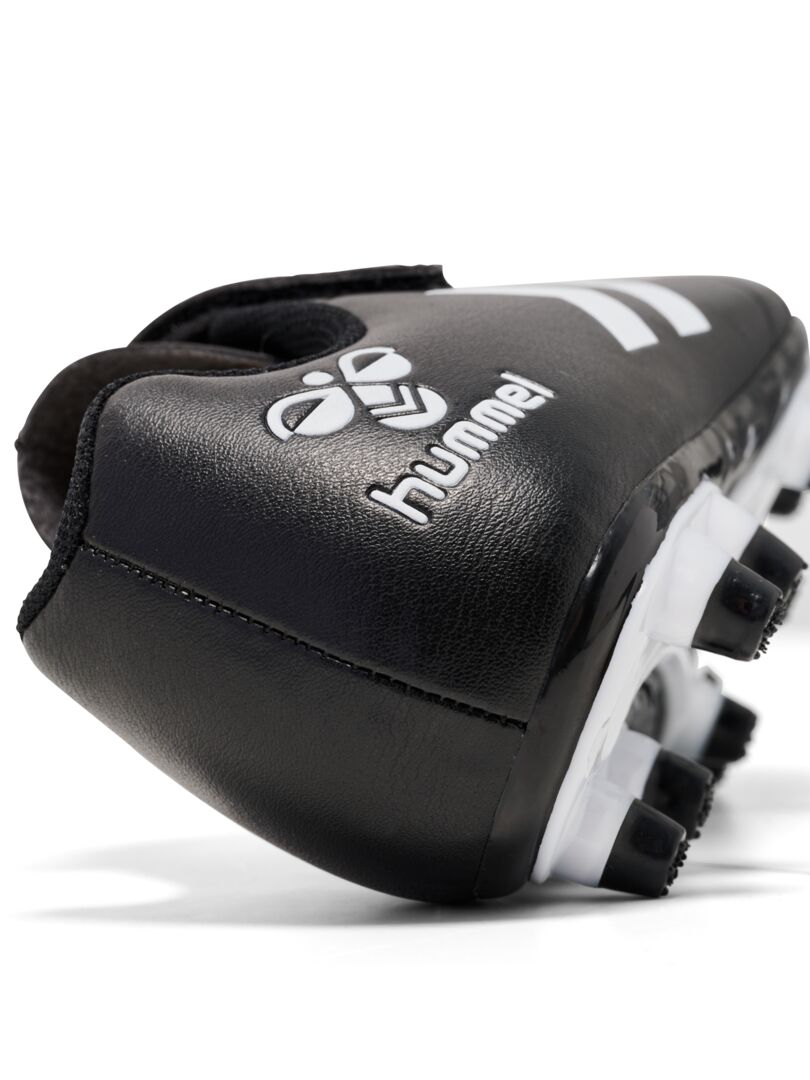 A firm ground football boot by Hummel, style Top Star F.G JR 216568-2042, in black and white with elastic lace and velcro fastening. Angled viewof heel.