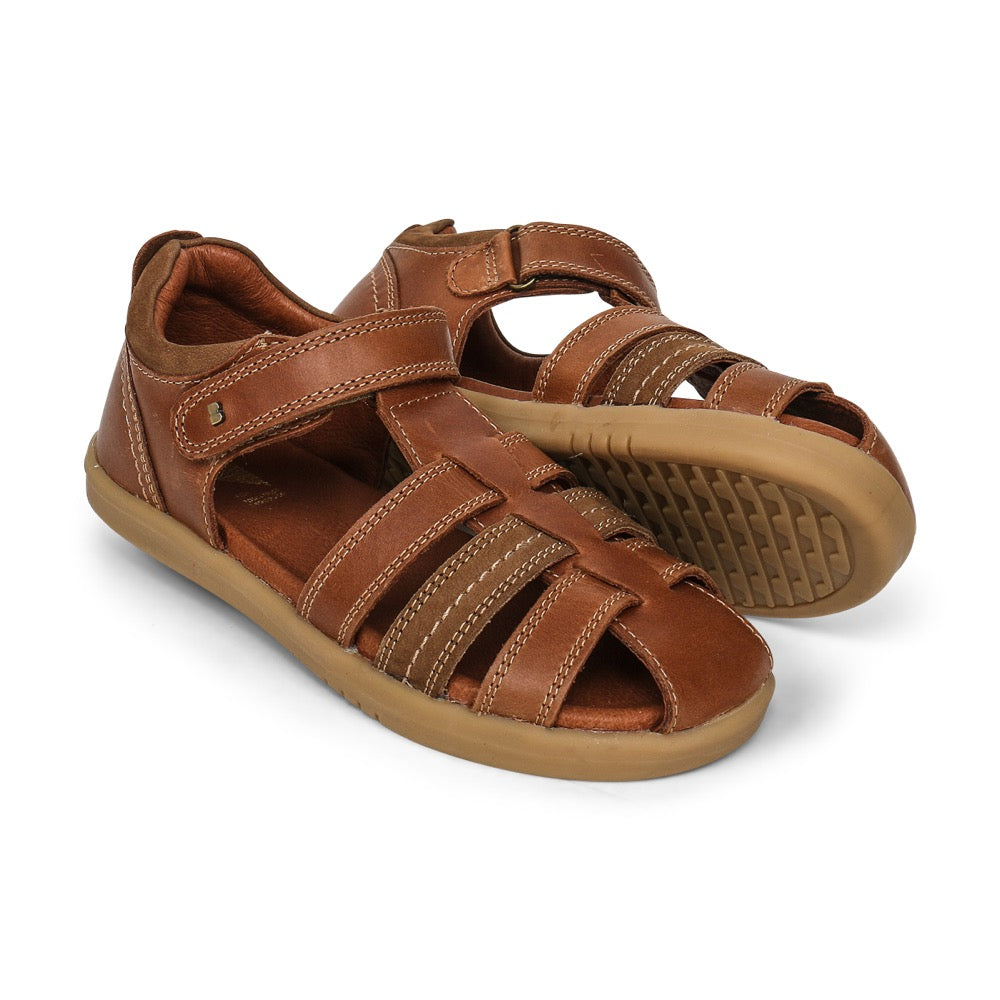 A unisex sandal by Bobux, style Roam in Caramel with velcro strap. View of pair with one sole showing
