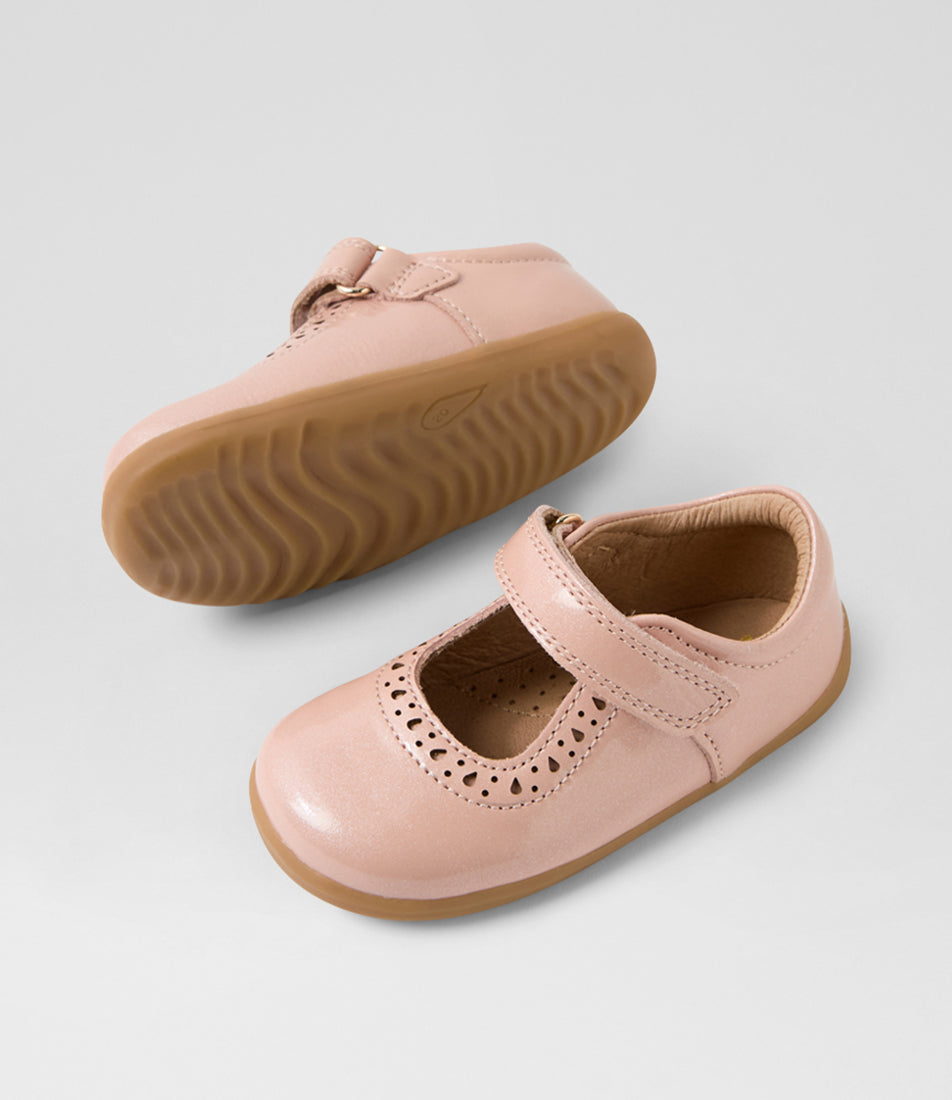 A girls casual shoe by Bobux, style Lola (I-Walk) in Cameo Rose with velcro strap, cut out pattern detail and light brown sole. View of pair with one sole showing