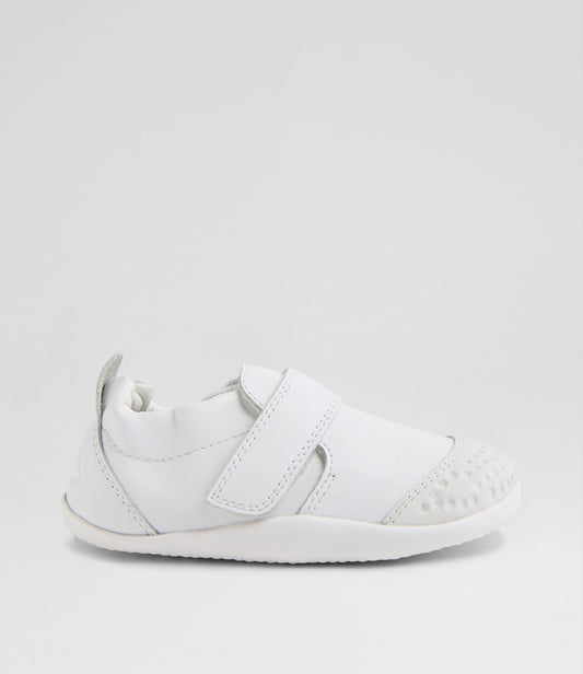 A unisex pre-walker shoe by Bobux, style Xplorer in white. With a velcro strap and front toe bumper. Right side view