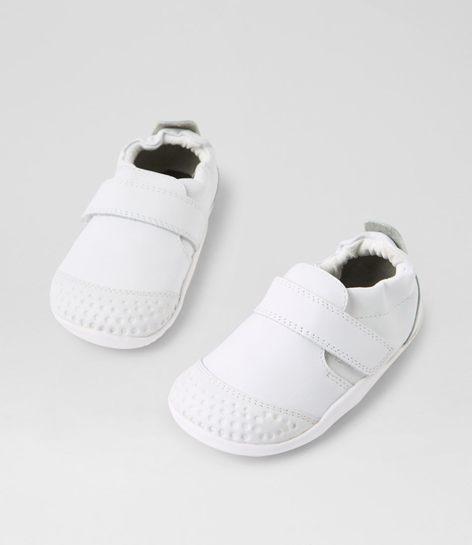 A unisex pre-walker shoe by Bobux, style Xplorer in white. With a velcro strap and front toe bumper. View of pair