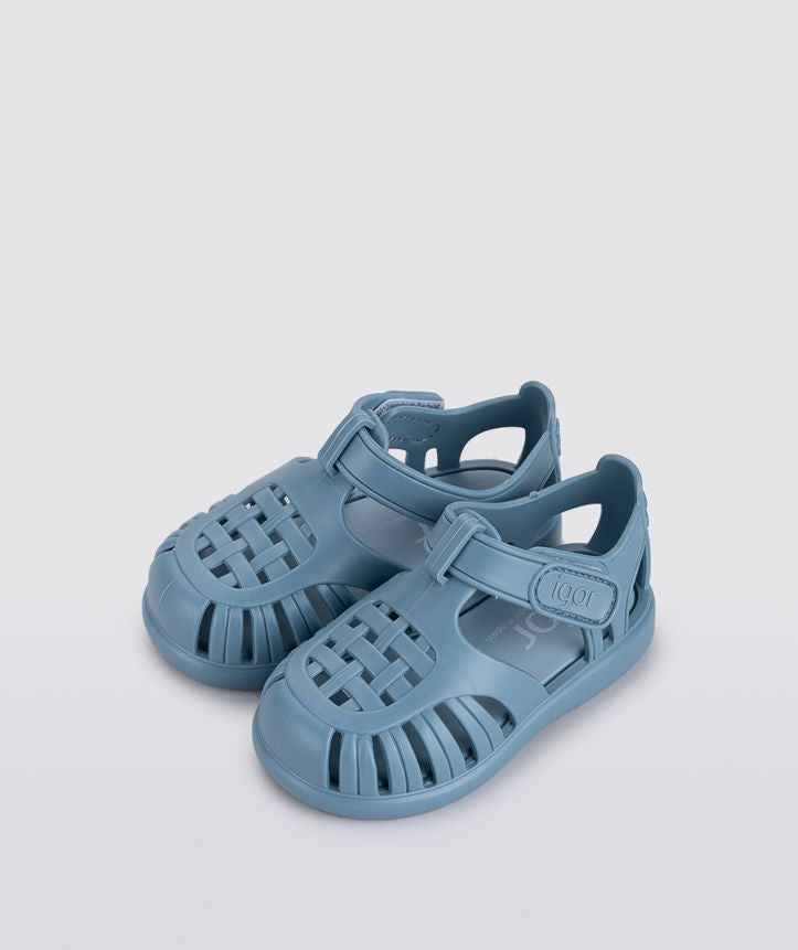 A child's closed toe unisex jelly sandal by Igor, style Tobby Solid, in oceano with velcro fastening. View of pair, angled left side view.