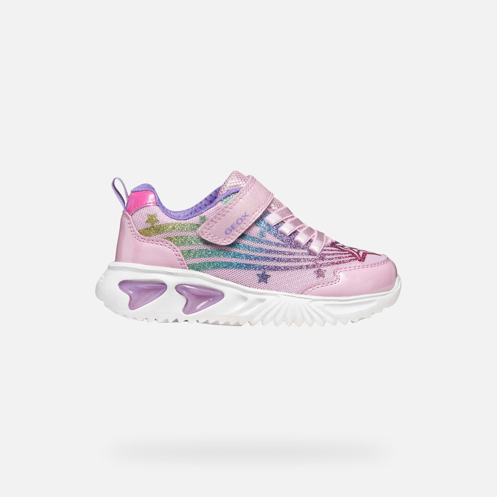 A pink girls trainer by Skechers, style Assister, in pink/multicolour with glittery rainbow and star design, velcro strap and pink laces. Right side view