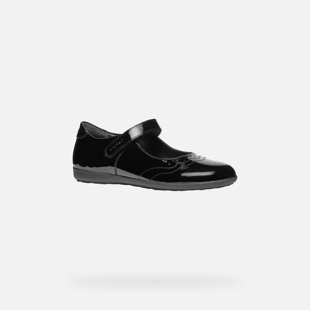 A girls Mary Jane school shoe by Geox, style J46MDG Iberide Girl, in black patent with punch hole detail and velcro fastening. Angled view.