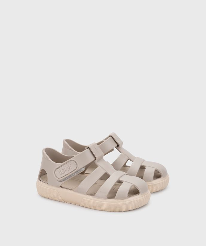 A child's closed toe unisex jelly sandal by Igor, style Bay, in sand with cream sole with velcro fastening. Angled right side view of a pair.