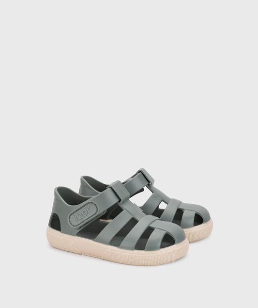 A child's closed toe unisex jelly sandal by Igor, style Bay, in green with cream sole with velcro fastening. Right side angled view of a pair.
