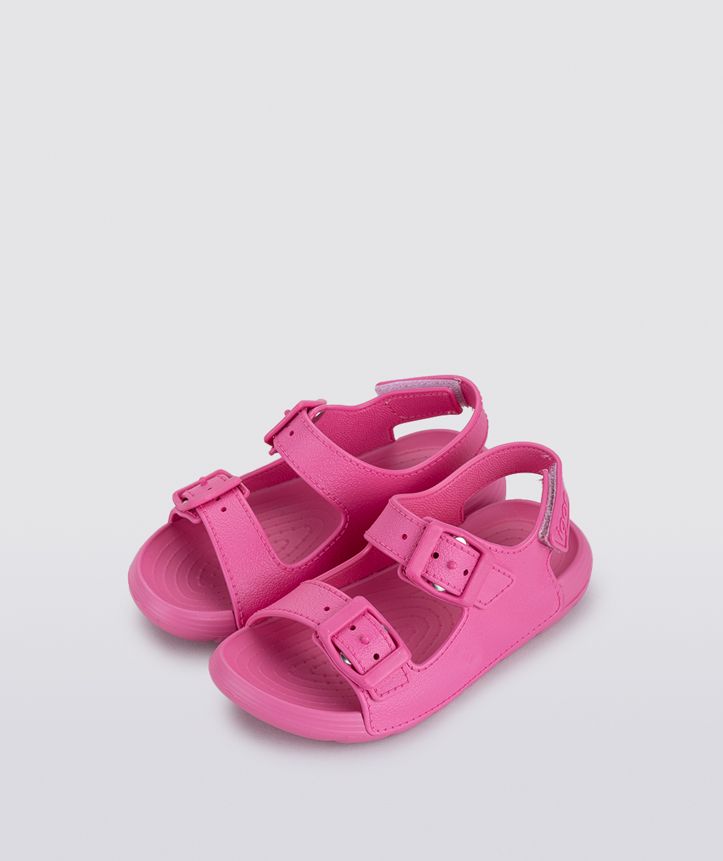 A girls sling back rubber shoe by Igor, style Maui in fucsia with two buckle straps and velcro heel fastening. Angled pair view.