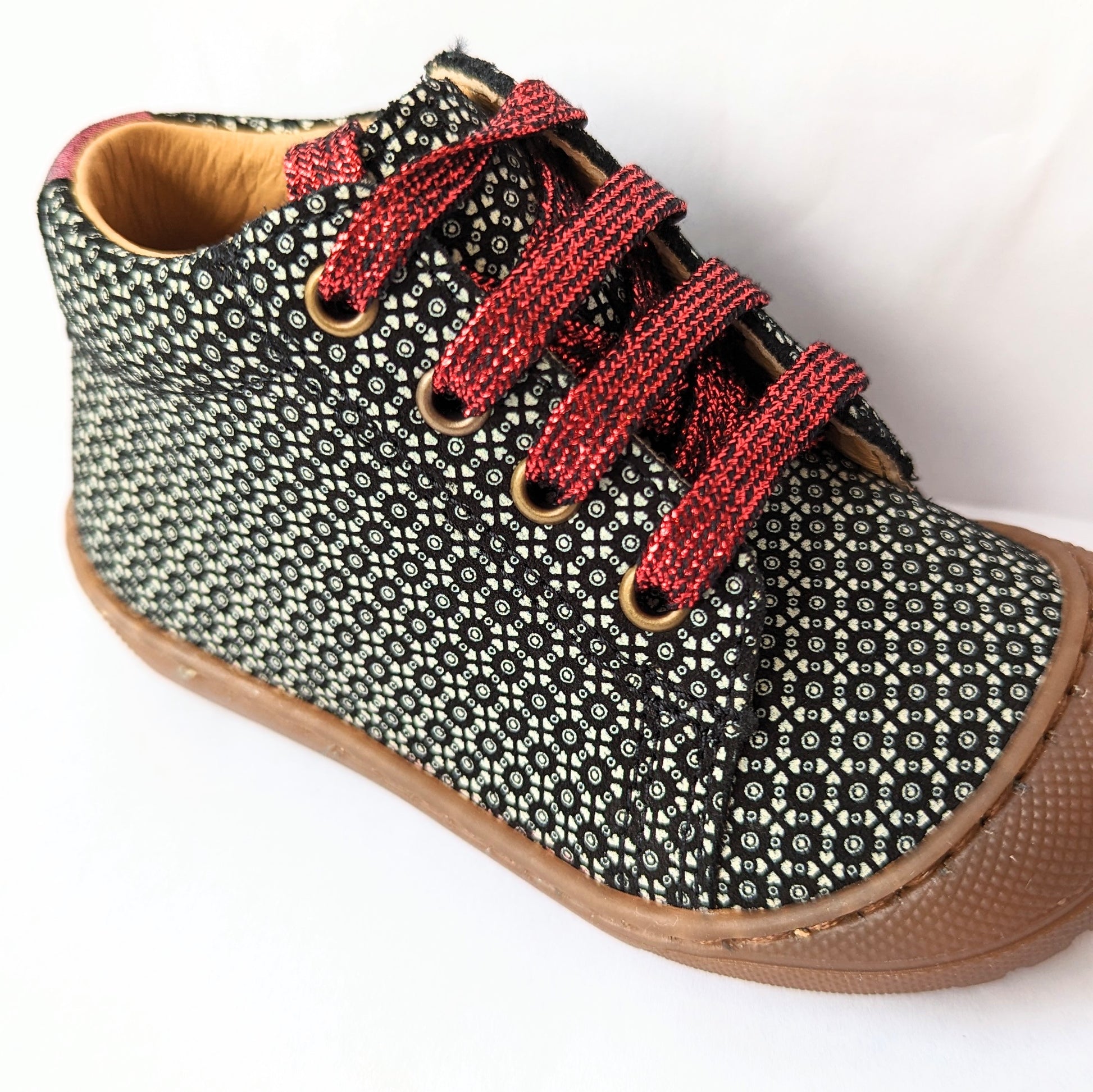 A girls ankle boot by Bopy, style Jolila, in black/silver print nubuck with toe bumper and zip/ bordeaux glitter lace fastening.  Close up angled view.