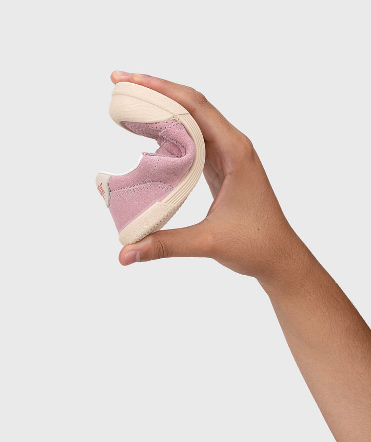 A girls casual shoe by Igor, style Tennis Fresh in Rosa with two velcro straps and toe and heel bumpers. Image of hand bending the shoe