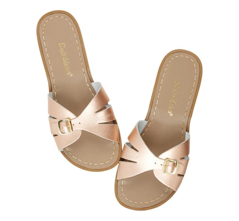 A Slide sandal by Salt Water Sandals in rose gold with single buckle fastening across the instep. Open toe and open back. Top view.