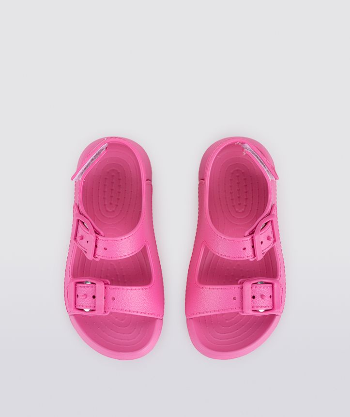A girls sling back rubber shoe by Igor, style Maui in fucsia with two buckle straps and velcro heel fastening. Top pair view.