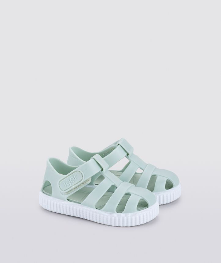 A unisex Jelly shoe by Igor, style Nico in mint green with a white sole, velcro fastening. Angled view of a pair.