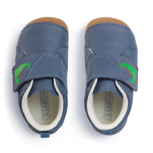 A boys pre-walker by Start-Rite, style Dinky, in blue with dinosaur motif on the velcro strap. Above view of a pair.