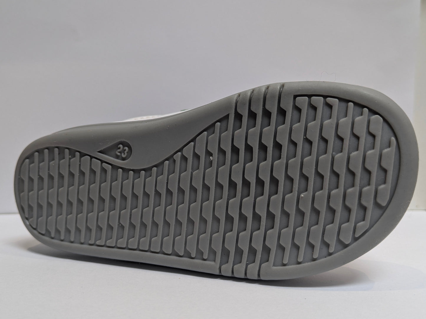 A girls casual shoe by Bobux , style I - Walk Blaze, in white with pink and blue metallic accents and grey sole. Double velcro fastening. Close up of sole.