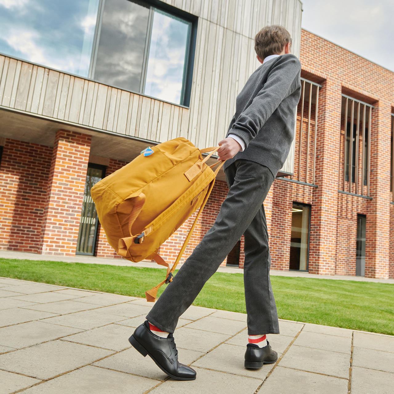 A school boy wearing a pair of boys smart school shoes by Start Rite, style Academy, in black leather with lace up fastening.