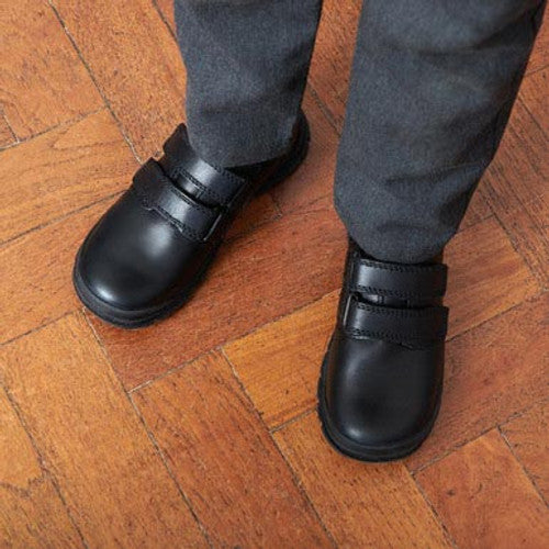 A boys school shoe by Start-Rite, style Engineer, in black leather with double velcro fastening. Lifestyle image.