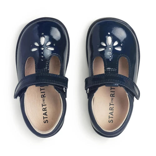 A girls t-bar shoe by StartRite, style Puzzle in patent navy, with flower design on the front and glitter in a black sole. Top view of pair