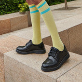 A girl wearing a pair of Start-Rite school shoes, style Impulsive, in black leather with lace up fastening. Angled view.