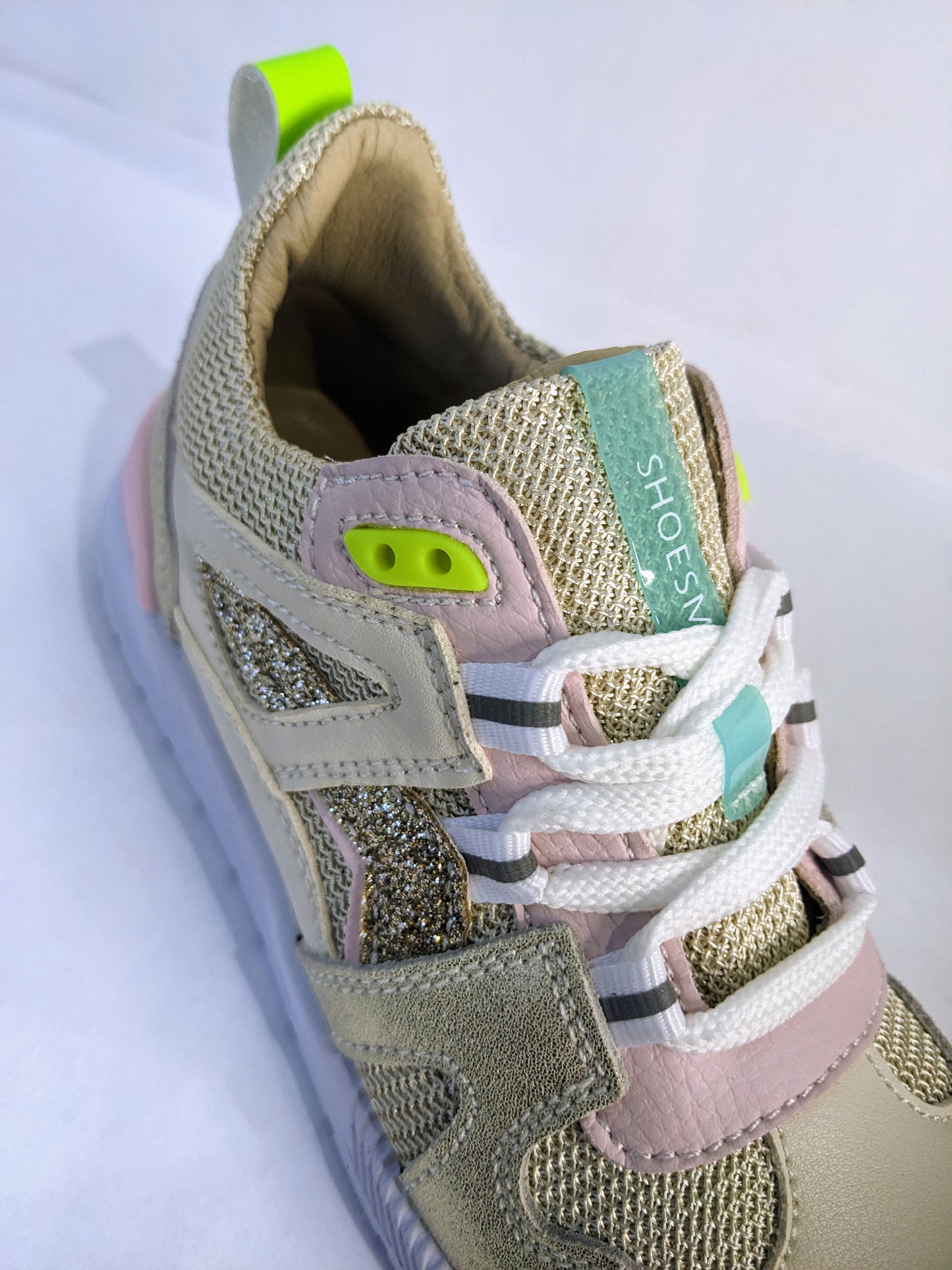 A girls trainer by Shoesme, style ST23S020-B, in beige/gold fabric and leather with lace fastening. Angled view.