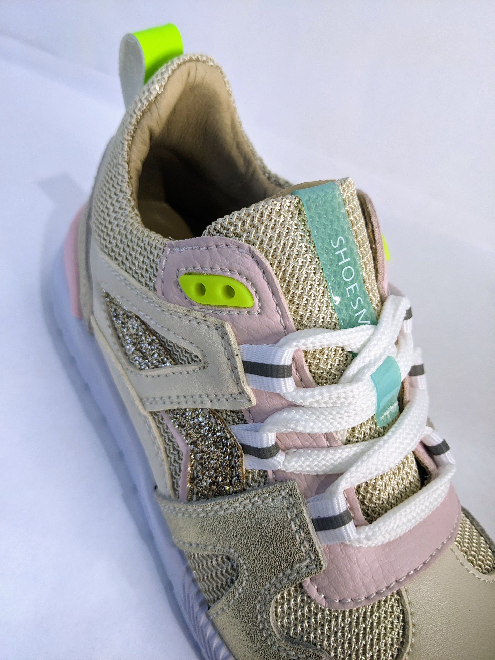 A girls trainer by Shoesme, style ST23S020-B, in beige/gold fabric and leather with lace fastening. Angled view.