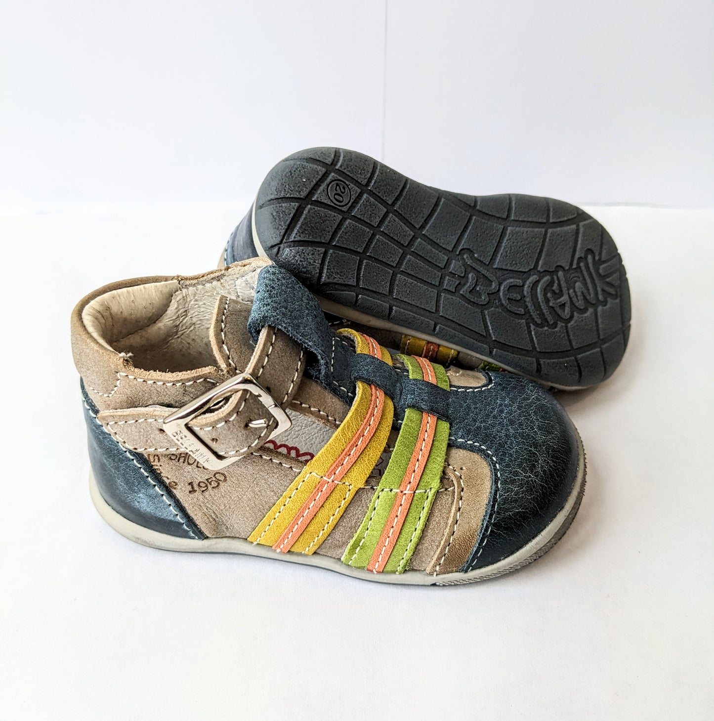 A boys T-bar shoe by Bellamy, style Belle, in blue and grey with orange, green and yellow stripes, buckle fastening. Right side view, left view of blue sole.