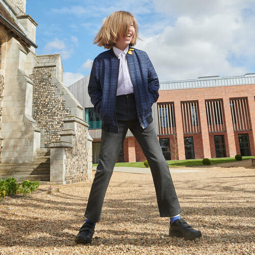 A boy wearing a pair of boys school shoes by Start Rite, style Warrior, in black leather with double velcro fastening. Front view.