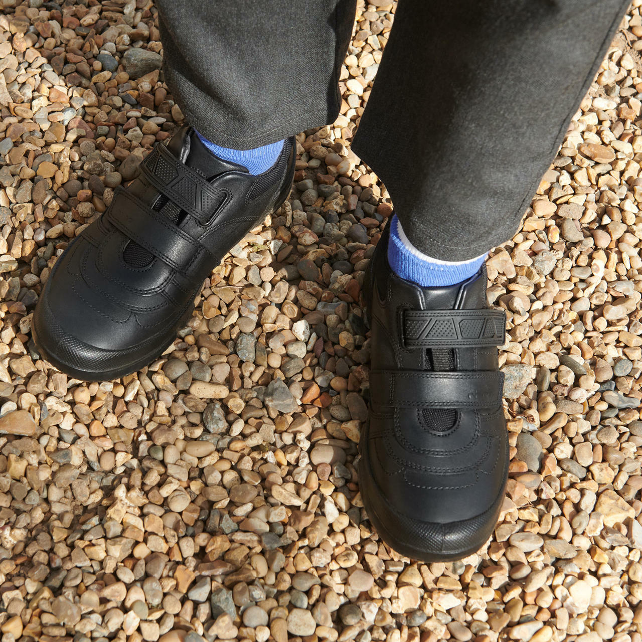 A boy wearing a pair of boys school shoes by Start Rite, style Warrior, in black leather with double velcro fastening. Above view.