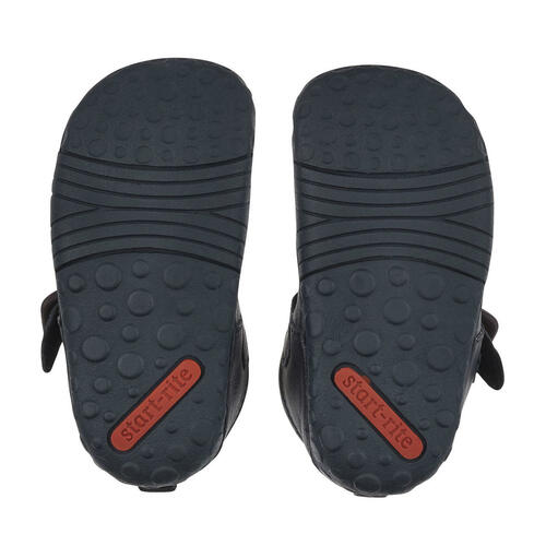 A boys T-Bar shoe by Start-Rite, style Baby Jack, in navy leather with punch out detail and buckle fastening. View of a pair,soles.